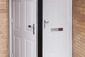 Double door entrance door in white with chrome handles and letterplate